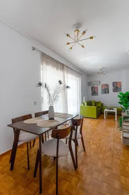 a dining room and living room with a table and chairs at Penthouse 2Bd apartment in the heart of Koukaki in Athens