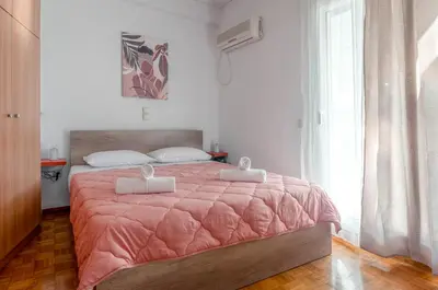 a bedroom with a bed with a pink comforter at Penthouse 2Bd apartment in the heart of Koukaki in Athens