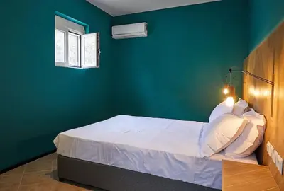 a bedroom with a bed with a green wall at Flyin' High Luxury Suite in Metókhi