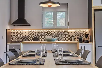 a kitchen with a table with plates and glasses on it at Flyin' High Luxury Suite in Metókhi