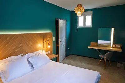 a bedroom with a bed and a desk and a bed sidx sidx sidx at Flyin' High Luxury Suite in Metókhi