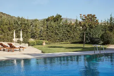 a swimming pool with two chairs and a swing at Flyin' High Luxury Suite in Metókhi