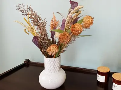 a white vase with flowers in it on a table at Beautiful house in Chalandri in Athens