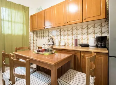 a kitchen with wooden cabinets and a wooden table and chairs at Beautiful house in Chalandri in Athens
