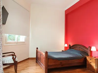 a bedroom with a red wall and a bed at Beautiful house in Chalandri in Athens