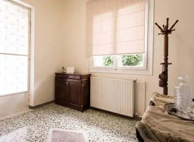 a bedroom with a bed and a window with a radiator at Beautiful house in Chalandri in Athens