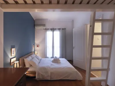 a bedroom with a white bed and a ladder at Fyllis17 - Cozy apartment in the heart of Athens in Athens