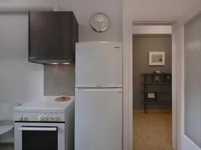 a kitchen with a white refrigerator and a clock on the wall at Fyllis17 - Cozy apartment in the heart of Athens in Athens