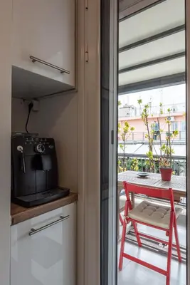 a small kitchen with a red chair and a table at Modern studio apartment B in Athens
