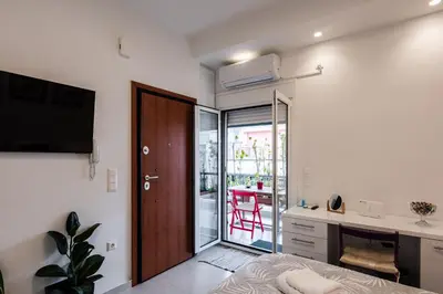 a bedroom with a bed and a desk and a sliding glass door at Modern studio apartment B in Athens
