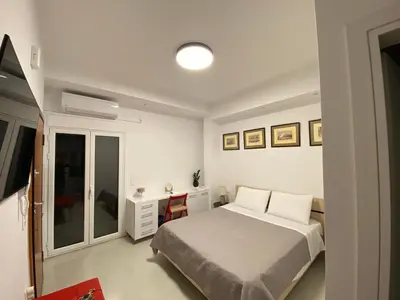 a white bedroom with a bed and a mirror at Modern studio apartment B in Athens