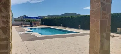 a swimming pool in a patio with mountains in the background at Evelina's studio in Artemida