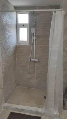 a bathroom with a shower with a shower curtain at Evelina's studio in Artemida