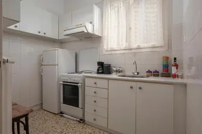 a white kitchen with a refrigerator and a sink at ΔΙΠΛΑ ΣΕ ΜΕΤΡΟ , ΚΟΝΤΑ ΣΤΗΝ ΑΚΡΟΠΟΛΗ in Athens