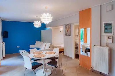 a dining room and living room with a table and chairs at Acropolis Studio Apartment in Athens