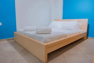 a bed with white sheets and pillows on it at Acropolis Studio Apartment in Athens