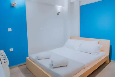 a bed with white sheets and pillows in a room at Acropolis Studio Apartment in Athens