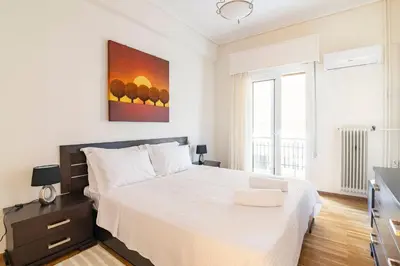 a white bedroom with a large bed and a window at Athens Walk in Athens