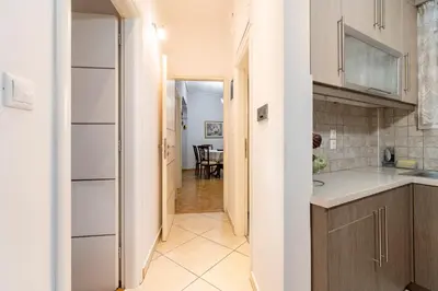 a kitchen with white cabinets and a dining room at Athens Walk in Athens