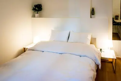 a bedroom with a white bed with two lamps at Acropolis Explorer Studio by WeHost Athens in Athens