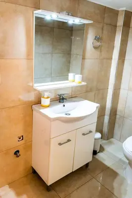 a bathroom with a sink and a mirror and a toilet at Acropolis Explorer Studio by WeHost Athens in Athens