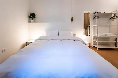 a bedroom with a large white bed in a room at Acropolis Explorer Studio by WeHost Athens in Athens