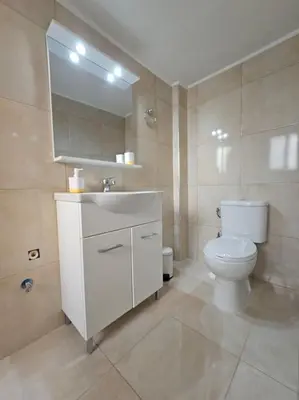 a bathroom with a toilet and a sink and a mirror at Acropolis Explorer Studio by WeHost Athens in Athens