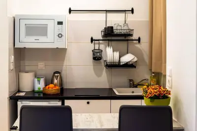 a kitchen with a black counter top and a microwave at Acropolis Explorer Studio by WeHost Athens in Athens