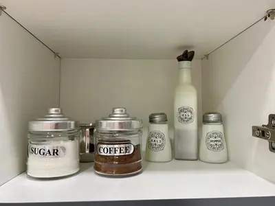 a shelf with four jars and a bottle of coffee at A modern flat in the centre in Athens