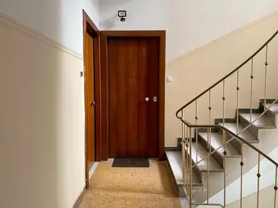 a hallway with a wooden door and stairs at A modern flat in the centre in Athens
