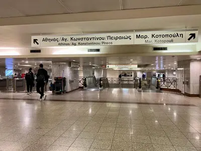 a person walking through an airport terminal with a sign at A modern flat in the centre in Athens