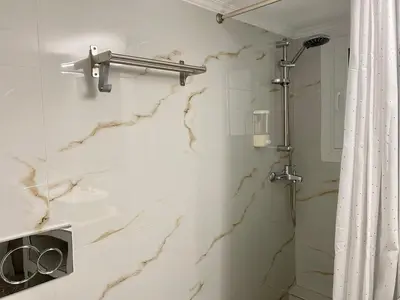 a bathroom with a shower and a marble wall at A modern flat in the centre in Athens