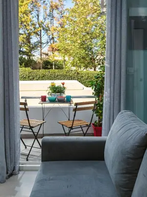 a living room with a couch and a table with chairs at Theo's Cozy Apartment's near Athens airport in Spáta