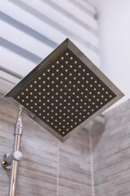 a light hanging from the ceiling in a bathroom at Theo's Cozy Apartment's near Athens airport in Spáta