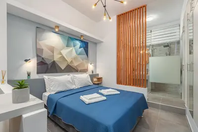 a bedroom with a blue bed and a shower at Theo's Cozy Apartment's near Athens airport in Spáta