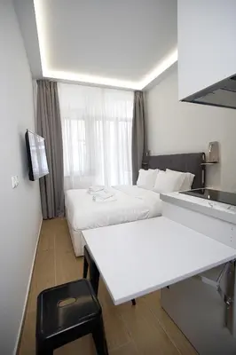 a small hotel room with two beds and a desk at TiP - ToP Suites in Athens