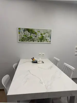 a white table with white chairs and a picture on the wall at TiP - ToP Suites in Athens