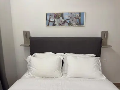 a bed with a black headboard with two white pillows at TiP - ToP Suites in Athens