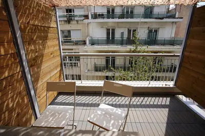 two chairs on a balcony with a building in the background at TiP - ToP Suites in Athens