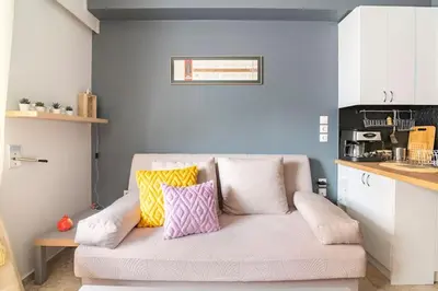 a living room with a couch with colorful pillows on it at Sunny apartment right under Parthenon in Athens
