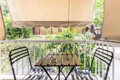 a wooden bench on a balcony with a table at Sunny apartment right under Parthenon in Athens