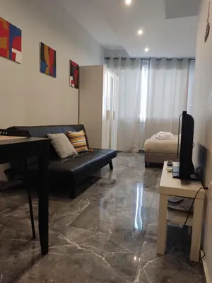 a living room with a black couch and a bed at COMFY Flat, Athens city center in Athens