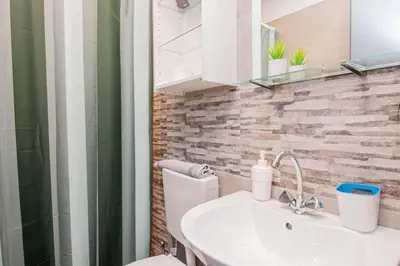 a bathroom with a white toilet and a sink at COMFY Flat, Athens city center in Athens
