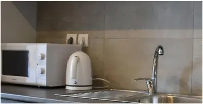 a kitchen counter with a sink and a toaster and a microwave at COMFY Flat, Athens city center in Athens