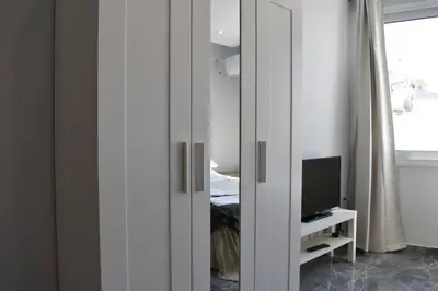 a mirror in a room with a tv and a bedroom at COMFY Flat, Athens city center in Athens