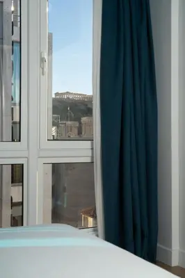 a bedroom with a window with a view of a city at Dion Luxury Suites in Athens