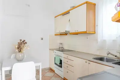 a kitchen with white cabinets and a sink at Spacious 2 bedroom apartment at Glifada in Athens