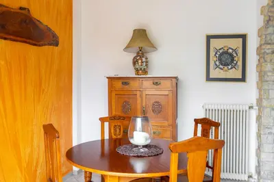 a dining room table with a lamp and a wooden cabinet at Spacious 2 bedroom apartment at Glifada in Athens