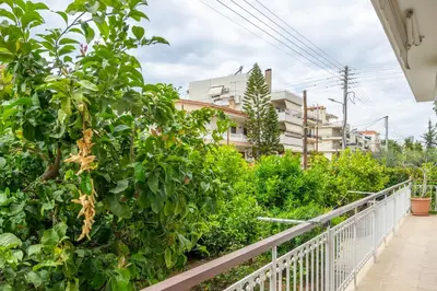 a balcony with green bushes and a building at Spacious 2 bedroom apartment at Glifada in Athens