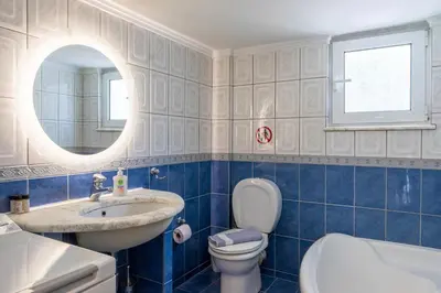 a bathroom with a sink and a toilet and a mirror at Spacious 2 bedroom apartment at Glifada in Athens